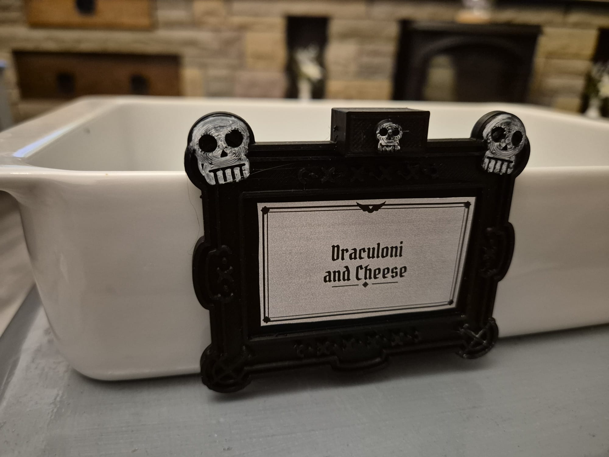 Skulls tag reading "Draculoni and Cheese" on a white ceramic dish