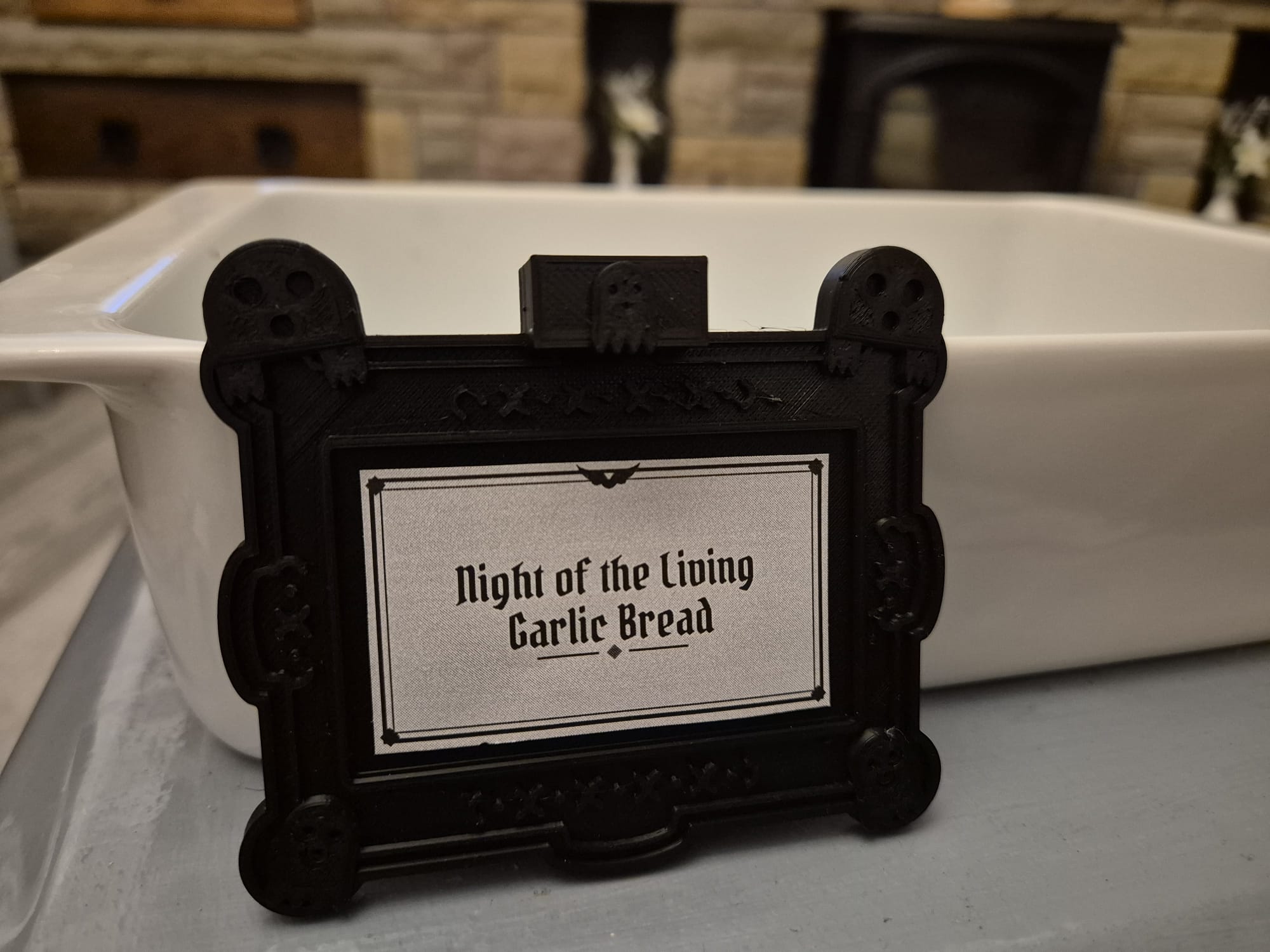 Ghosts tag reading "Night of the Living Garlic Bread" on a white ceramic dish