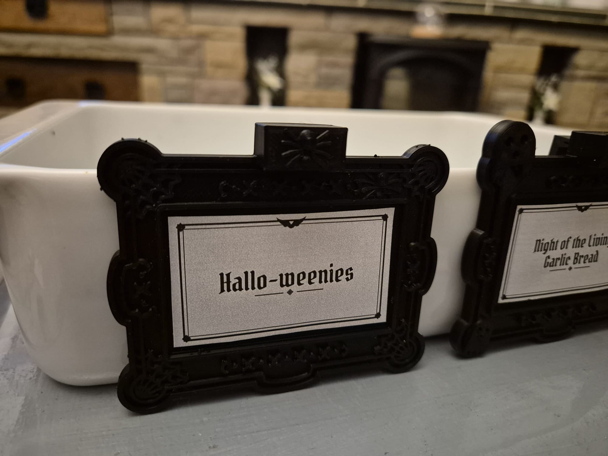 Tag reading "Hallo-weenies" on a white ceramic dish